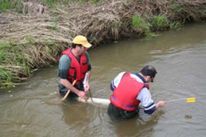 Soil experts David Lobb and Sheng Li check sediment collection traps. The sediment is collected annually to track the origin and pattern of soil migration. Image credit Landice Yestrau.